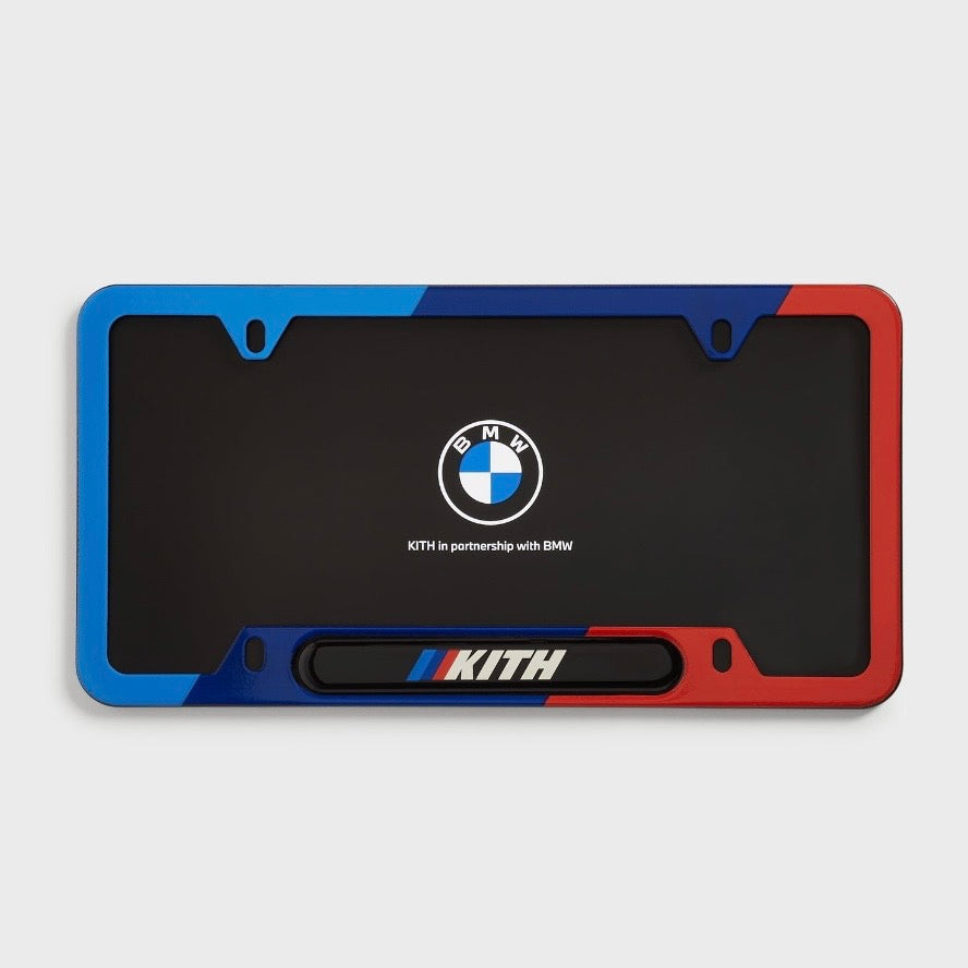 Kith BMW Multi License Plate Holder, the coloured frame fitted around a black plate showing the BMW roundel and Kith bar