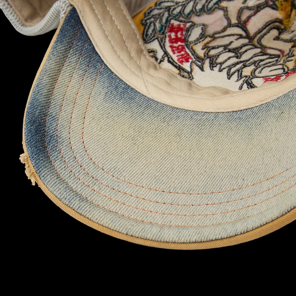 Close-up of the cap's pale blue and cream underbrim with orange topstitching
