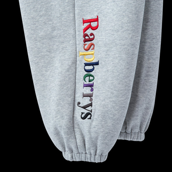 Close-up of the multicolour Raspberrys embroidery on the grey sweatpant leg