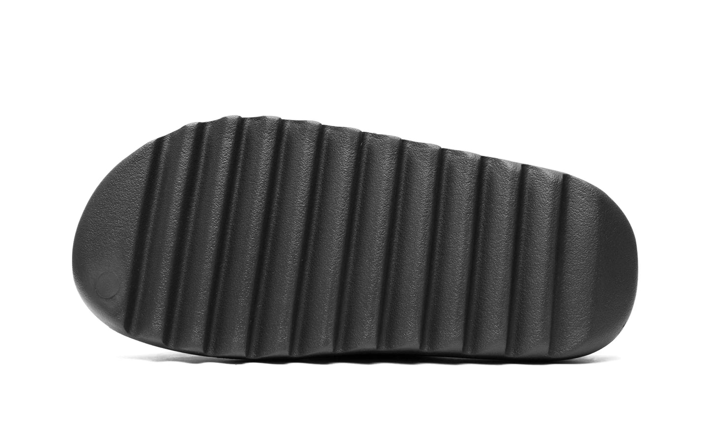 Yeezy Slide Dark Onyx, outsole view of the slide showing the deep horizontal tread bars.