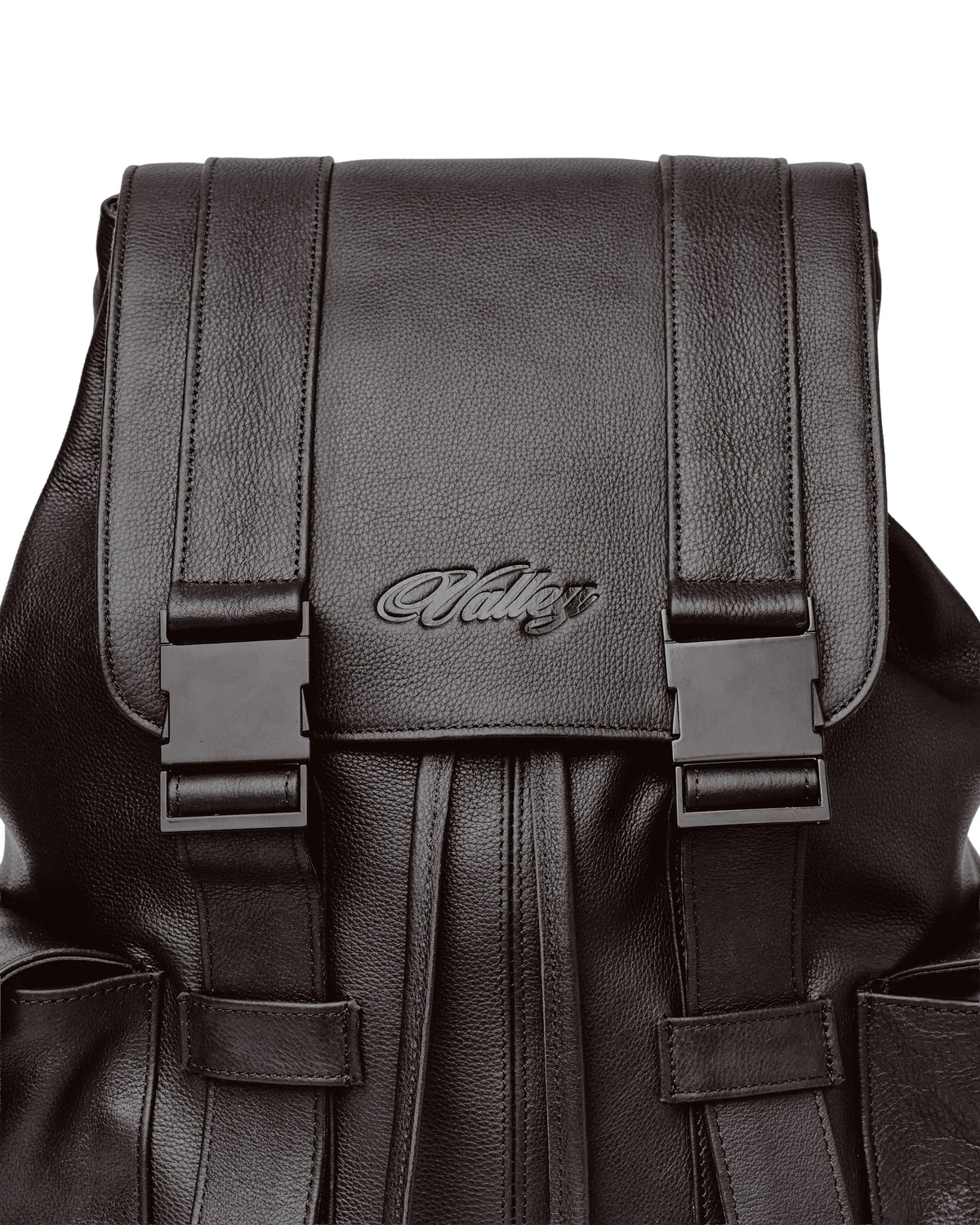 Vale Chocolate Tactician Backpack flap close-up with the embossed Valley script and matte buckles