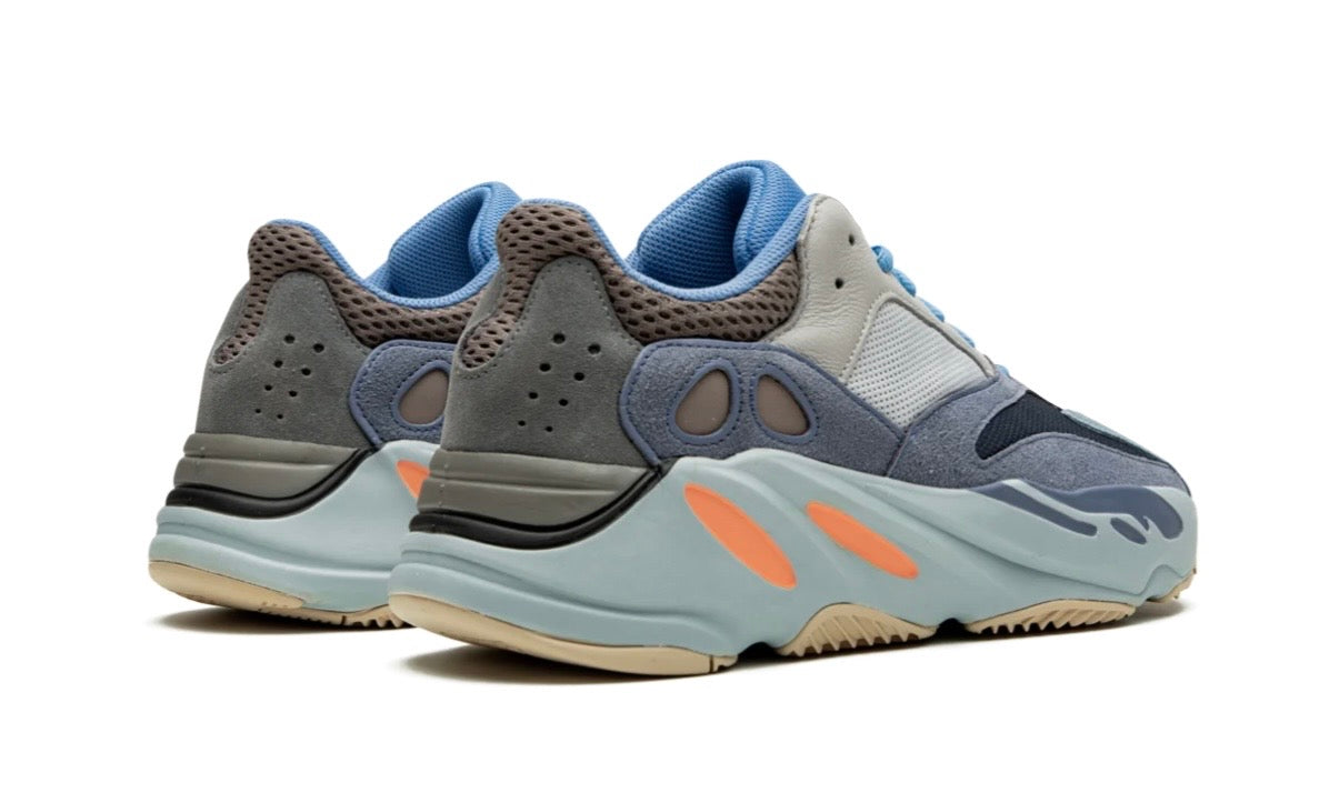 Adidas Yeezy 700 Carbon Blue, pair angled from behind, grey and blue heel panels above pale blue wavy midsoles