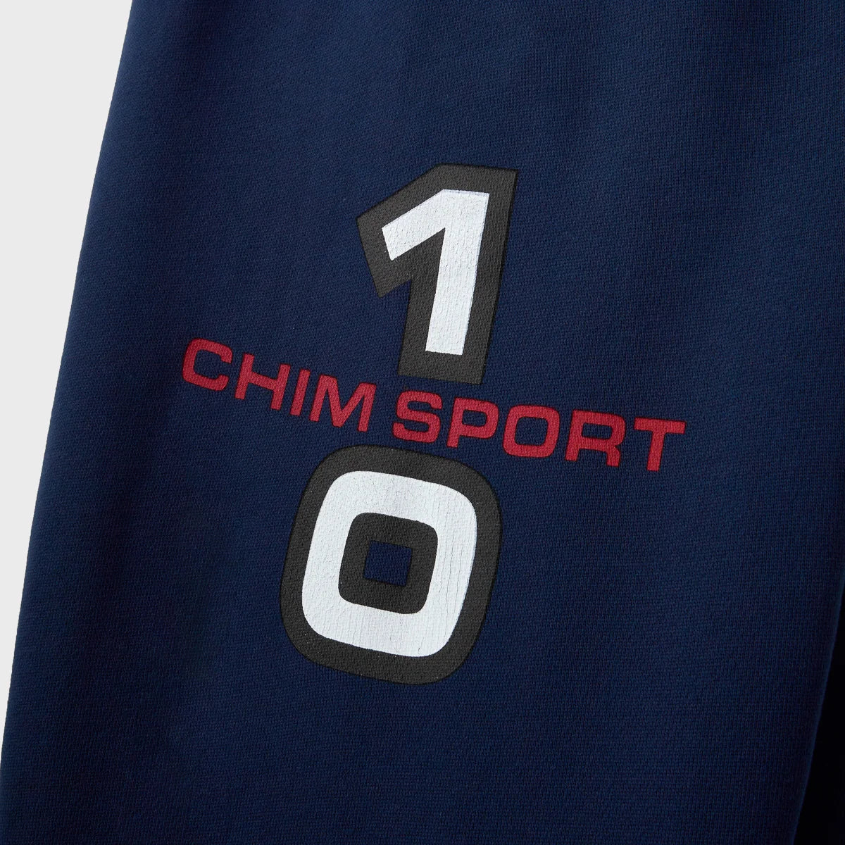 Close-up of the white 1 and 0 numerals and red CHIM SPORT text on navy fleece