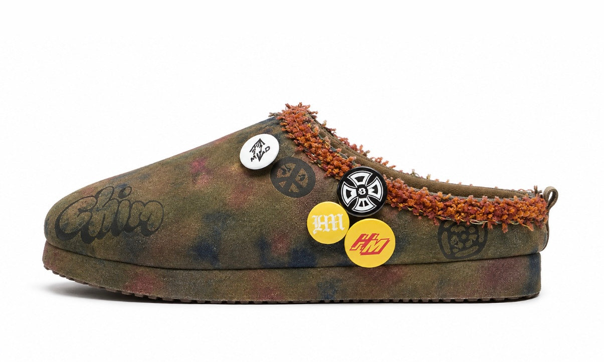HMDD Graffiti Mule, side view of the mottled olive and purple suede clog with orange shearling trim and enamel pin badges