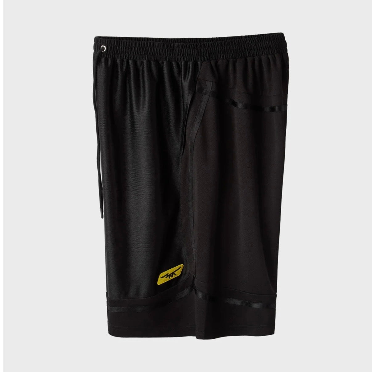 HMDD Black Mixtape Shorts, angled view of the black mesh shorts showing the yellow logo near the hem and side seam