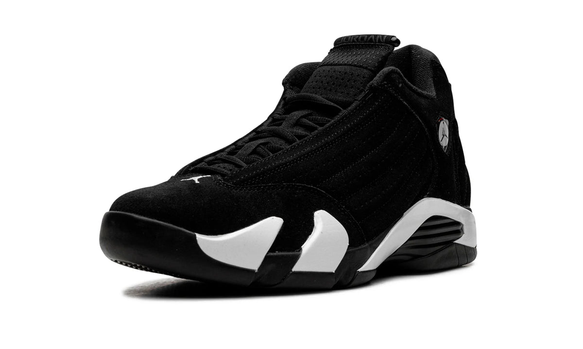 Jordan 14 Black White, front-left angle of one shoe, black suede upper, black laces, white midsole swoop