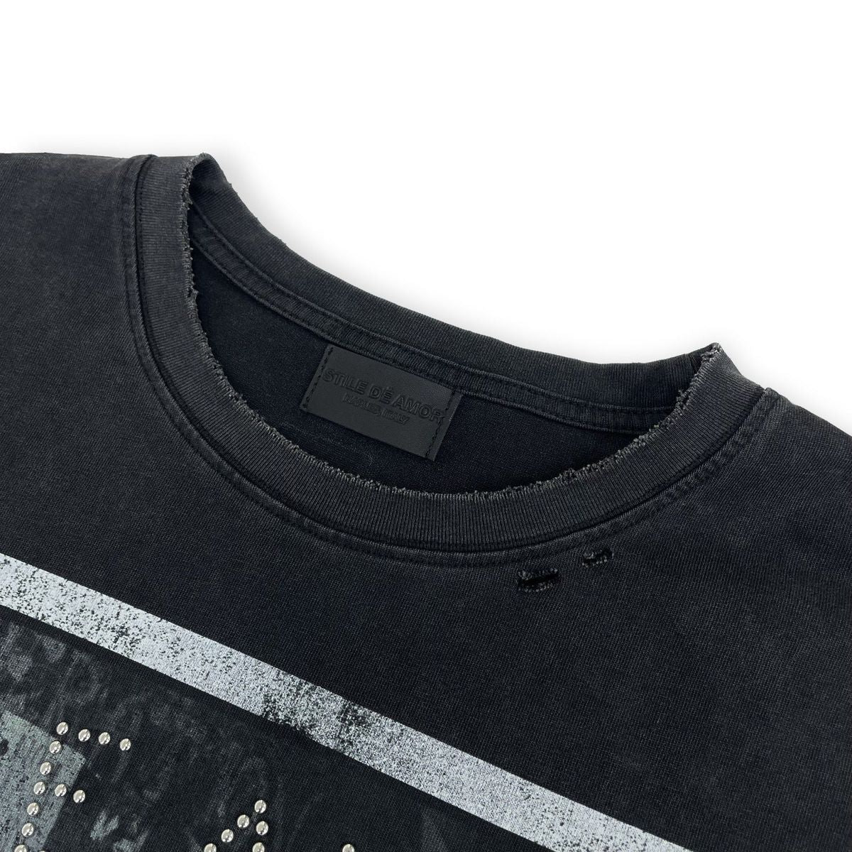Close-up of the ribbed crew neckline and distressed pinholes on washed black fabric