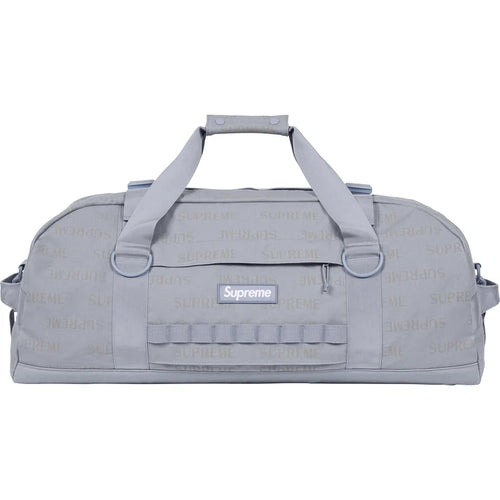 Supreme Light Blue Large Duffle Bag FW26, side view showing the tonal repeating SUPREME print, webbing daisy-chain loops and the blue Supreme box logo patch