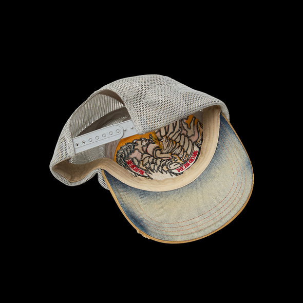 Tilted trucker cap showing the cream underbrim and interior sizing strap