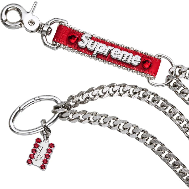 Close-up of the red rhinestone Supreme fob, silver curb chain and charm on the Supreme x b.b. Simon chain