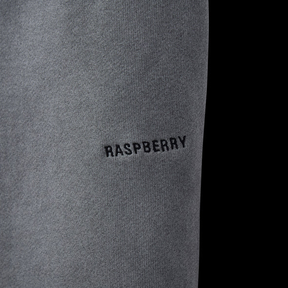 Close-up of tonal RASPBERRY embroidery on the back of the grey sweatpant leg