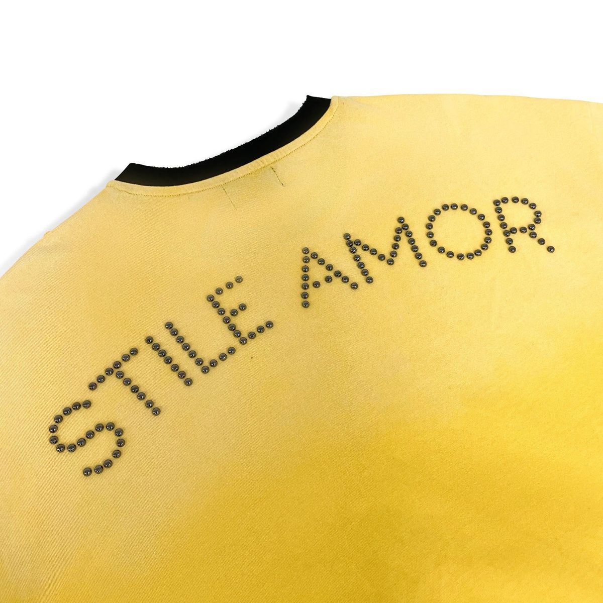 Stile De Amor Yellow Popolare T-Shirt, close-up of the cracked arched STILE AMOR print on the yellow back panel