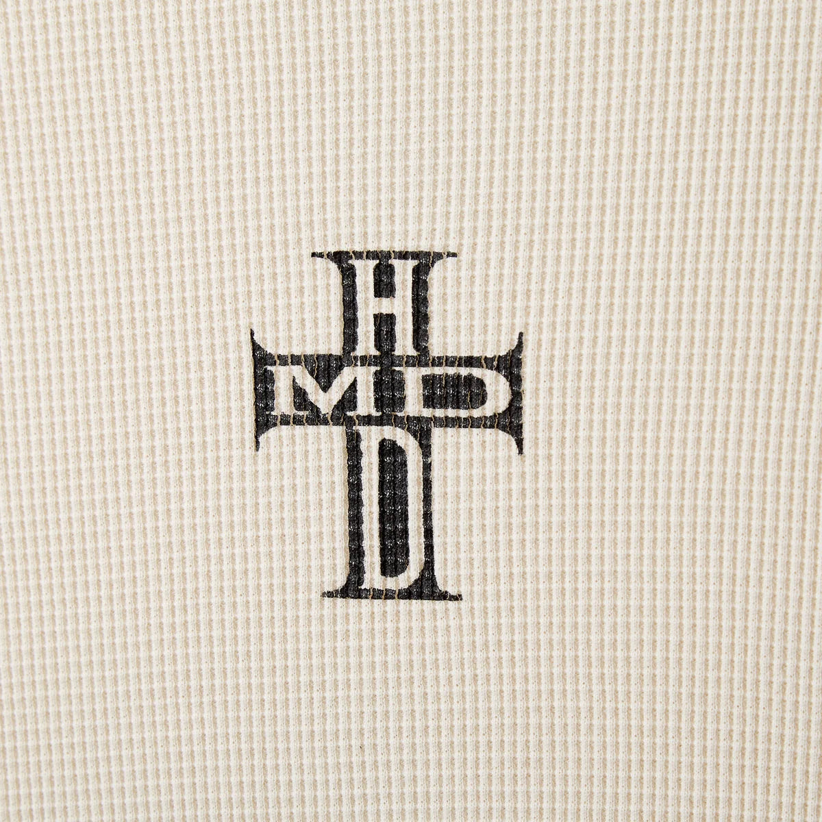 HMDD HC Thermal Long Sleeve, close-up of the black HMD cross monogram on the waffle knit