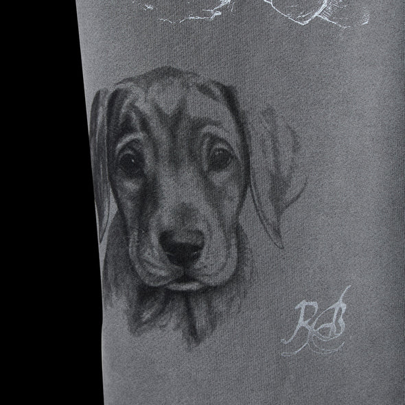 Close-up of the detailed pencil-sketch puppy portrait printed on the grey leg