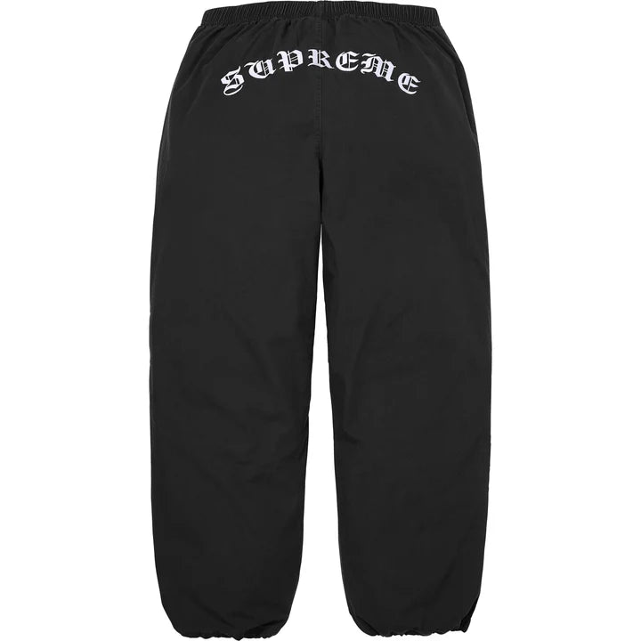 Back of the black Supreme x Umbro track pants with arched gothic Supreme embroidery below the waistband