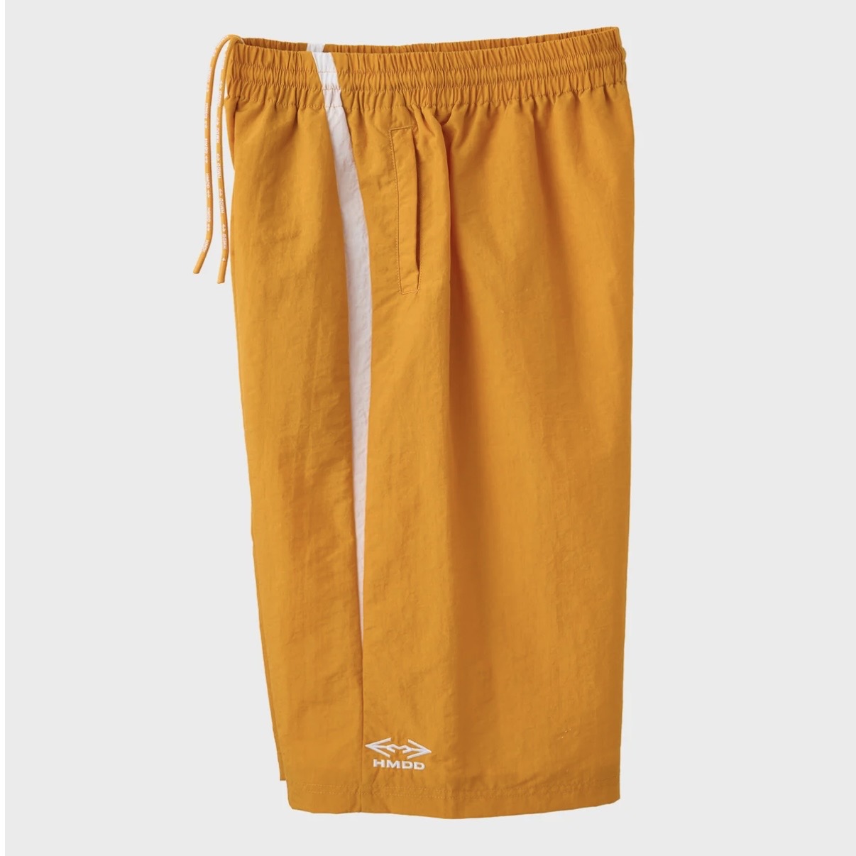 HMDD Gold Juggernaut 3/4 Shorts, angled view of the orange shorts showing the white side stripe and small hem logo