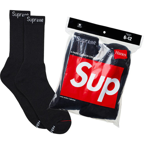 Supreme Hanes Black Crew Socks 4 Pack, two black ribbed crew socks beside the sealed four-pack bag with a red box logo