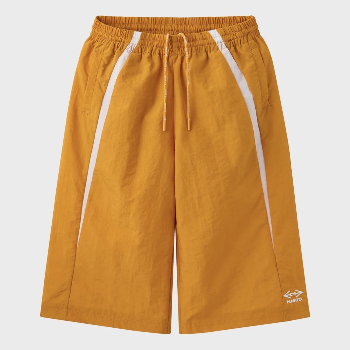 HMDD Gold Juggernaut 3/4 Shorts, orange nylon long shorts with a white side stripe, drawcord waist and logo above the hem