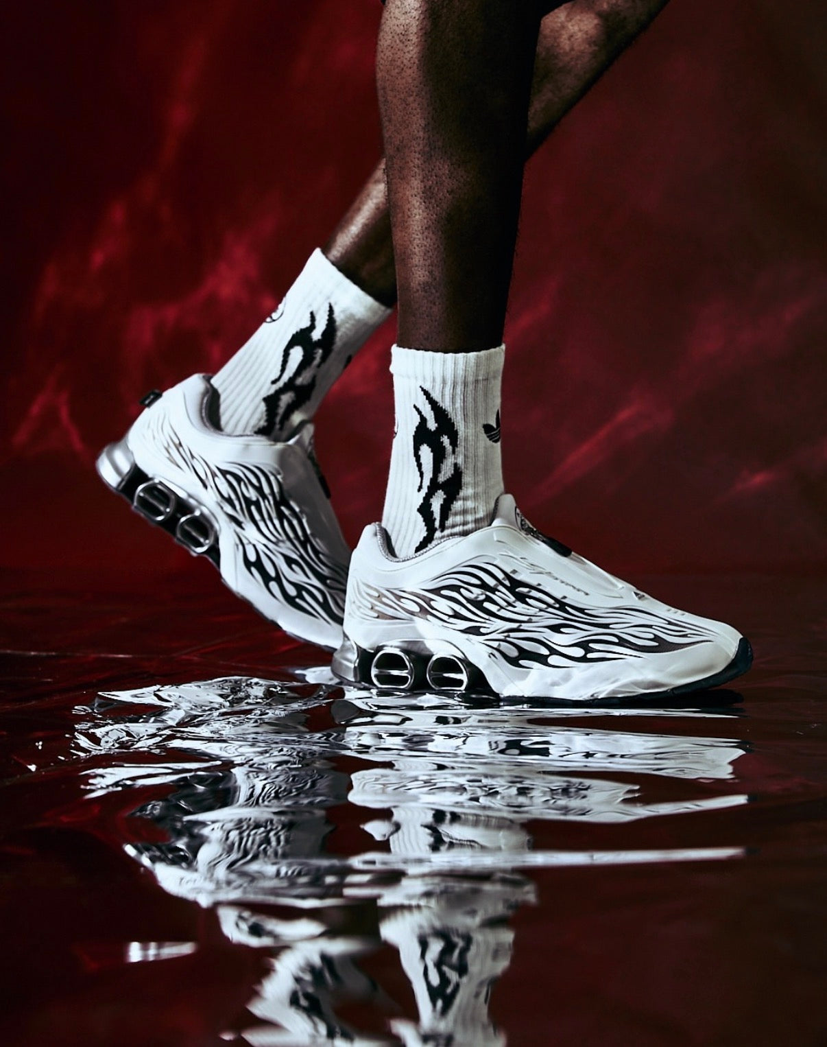 Hellstar Adidas Megaride White, on-body close-up of the shoes worn with white socks on a wet reflective floor