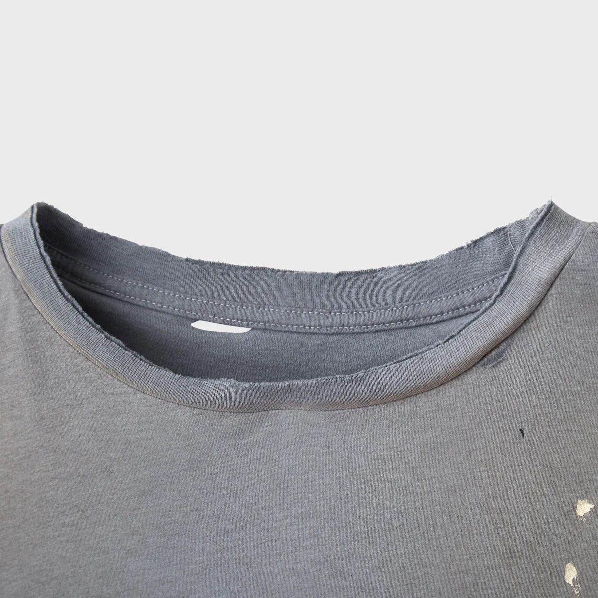 Close-up of the distressed collar and paint flecks on the grey tee