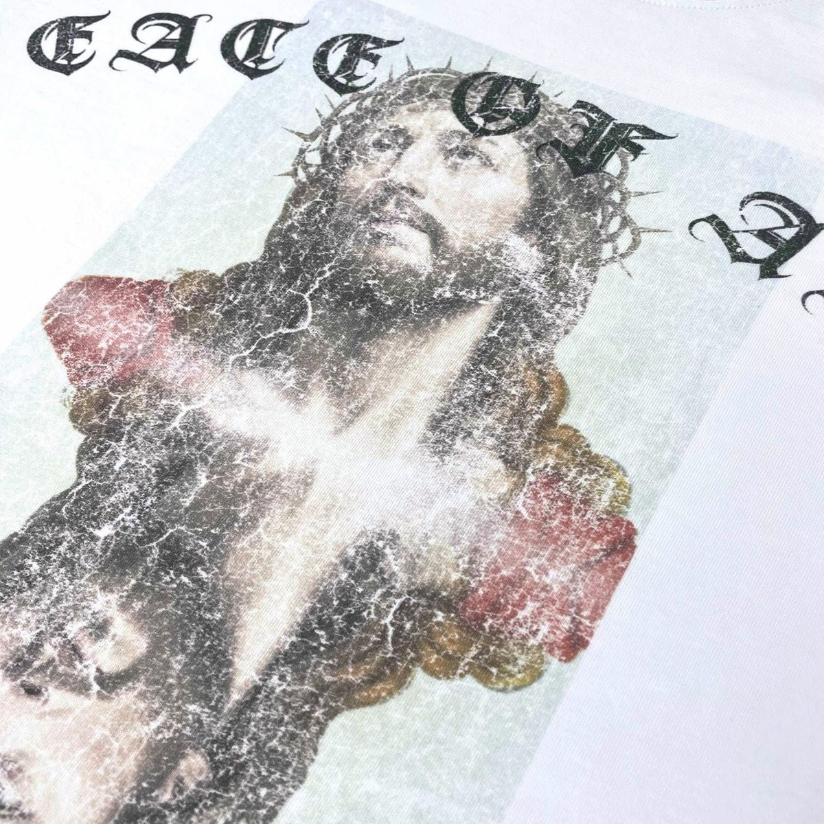 Stile De Amor White Peace of Amor T-Shirt, close-up of the printed crucifixion image and gothic lettering on white cotton