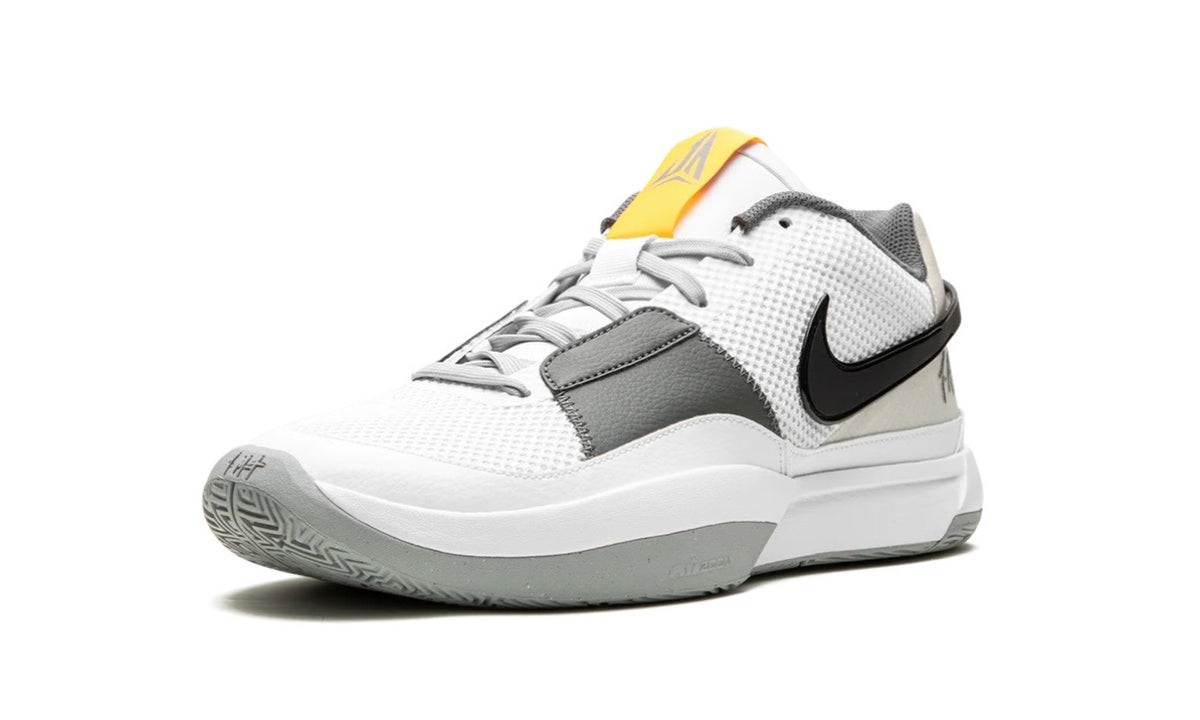 Nike Ja 1 Light Smoke Grey, angled front view showing the yellow tongue tab and black Swoosh