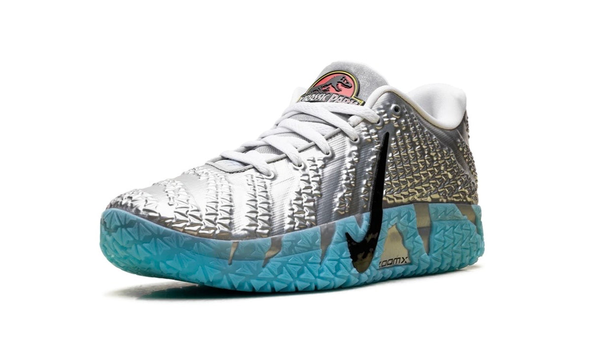 Front three-quarter of silver Nike Ja 3 showing Jurassic Park roundel on tongue