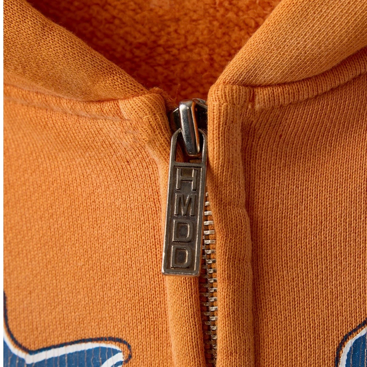 HMDD Cropped OC Summer Zip Hoodie, close-up of the metal zip pull stamped HMDD and the brushed fleece inside the hood