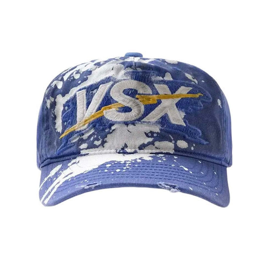 Vale Blue VSX Paint Splatter Hat front — royal blue cap with white VSX embroidery, a gold bolt and paint splatter