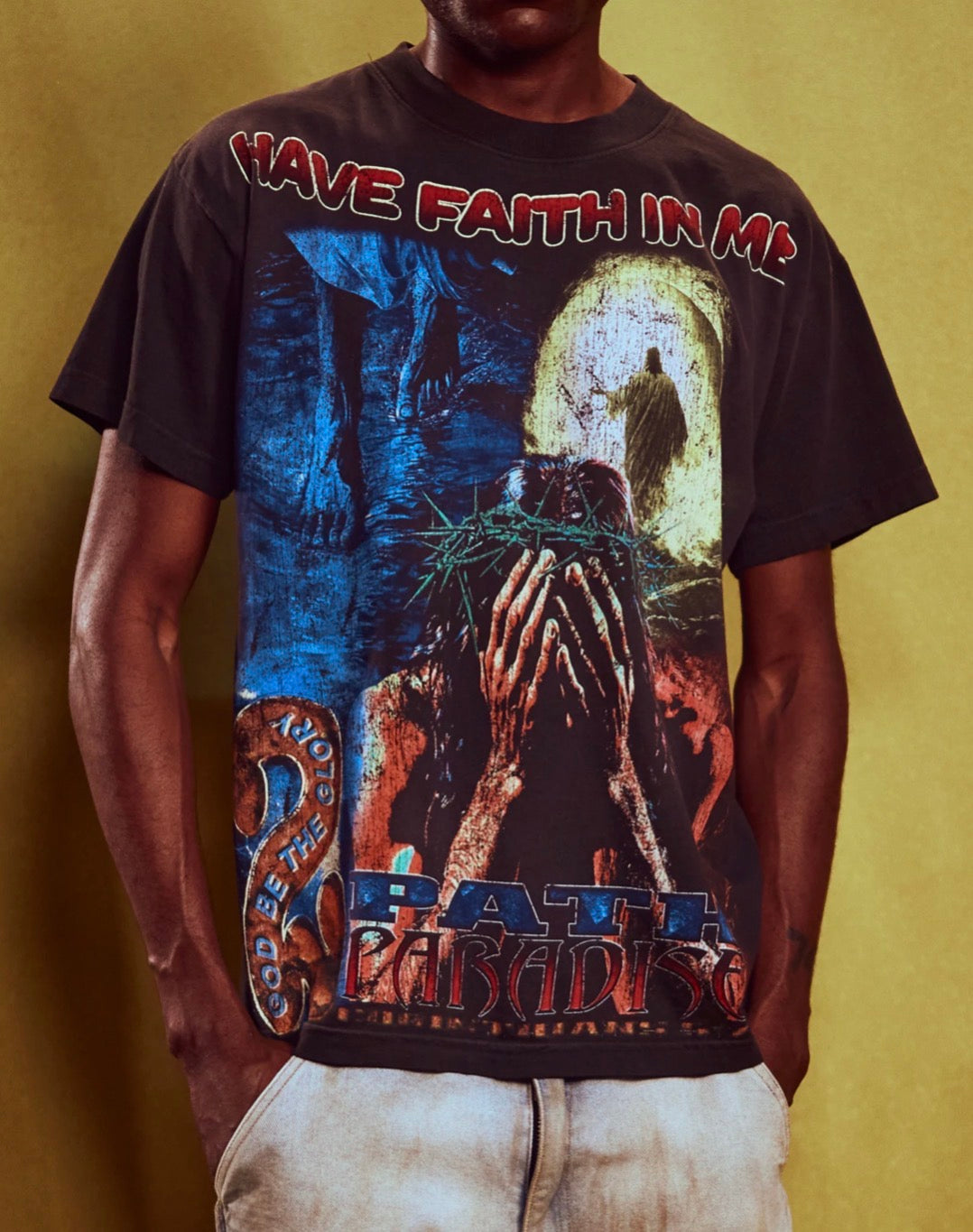 Hellstar Black Have Faith In Me T-Shirt, model wearing the printed tee with cream distressed jeans, cropped to the torso