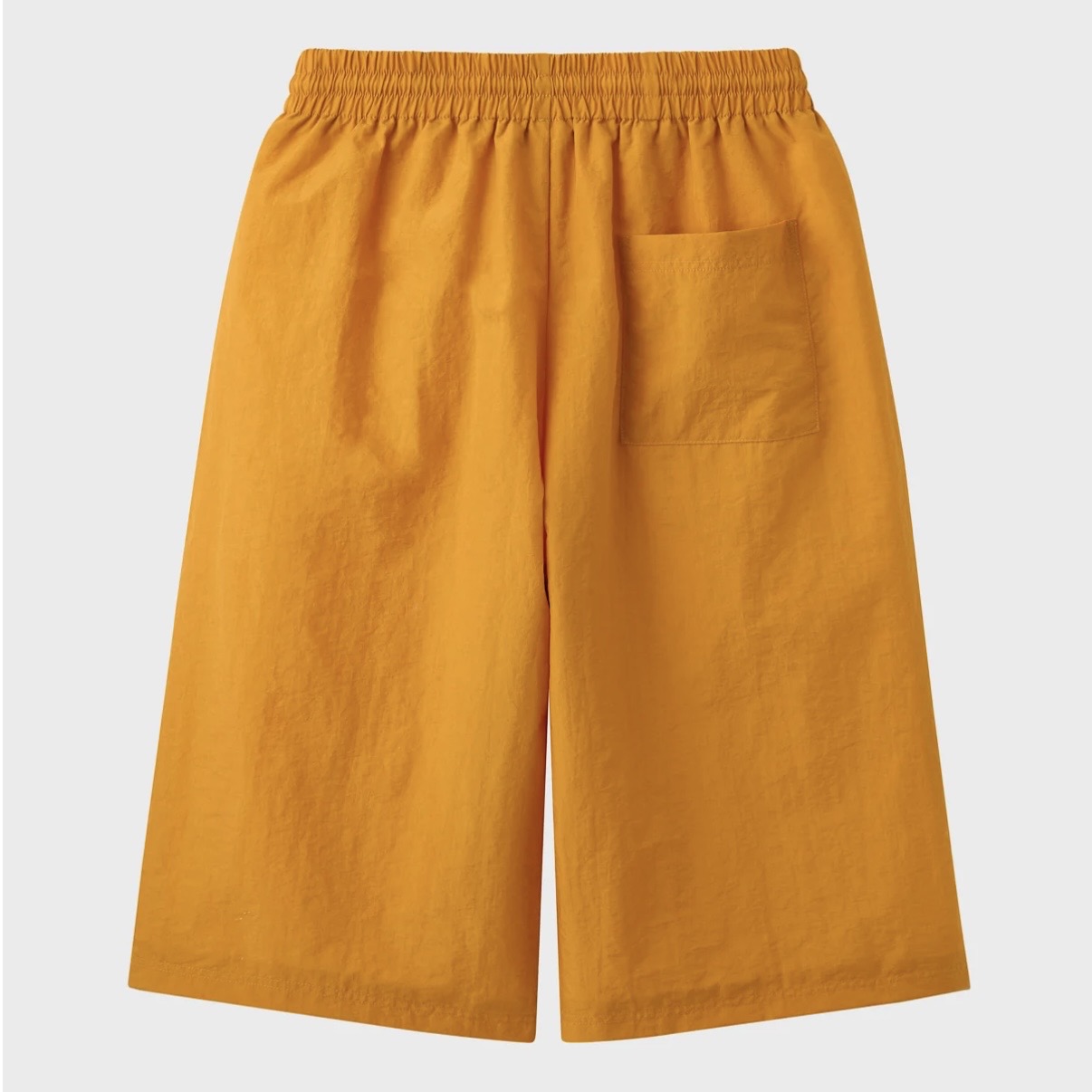 HMDD Gold Juggernaut 3/4 Shorts, back of the orange nylon shorts with an elastic waist and a patch pocket