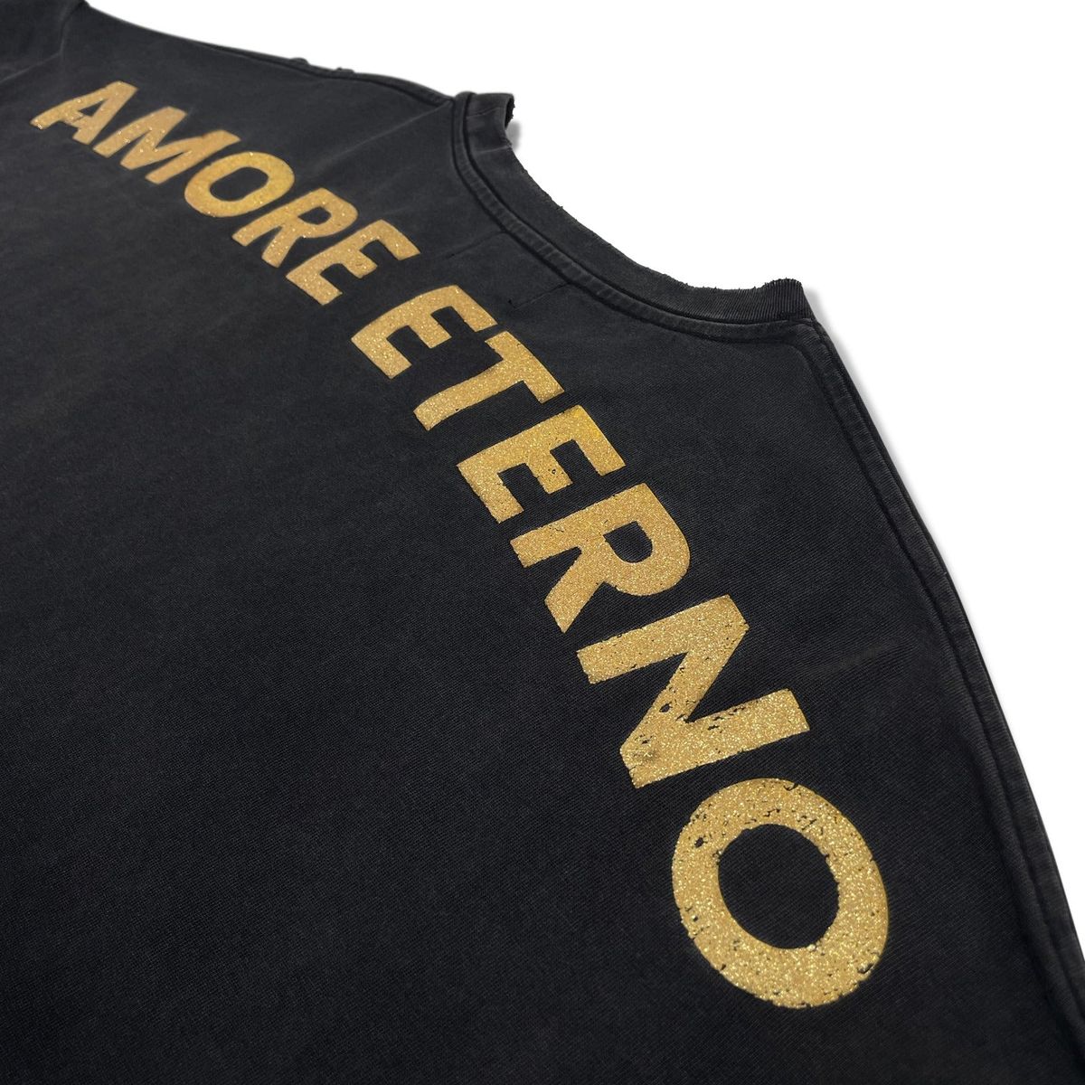 Close-up of gold AMORE ETERNO lettering across the shoulder of the washed black top