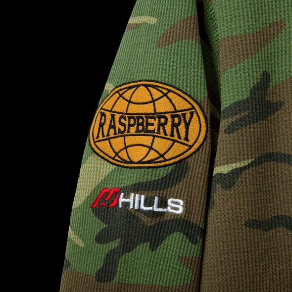 Close-up of the orange globe RASPBERRY patch and red HILLS mark on green camo