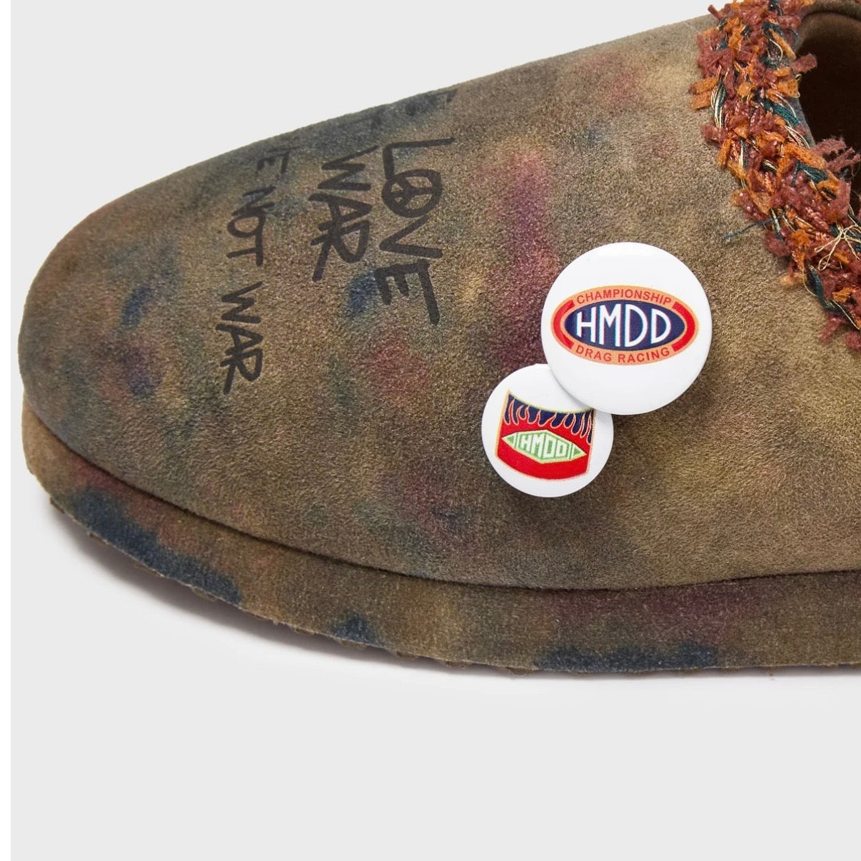 HMDD Graffiti Mule, close-up of the toe with LOVE NOT WAR script and red and white HMDD enamel pins