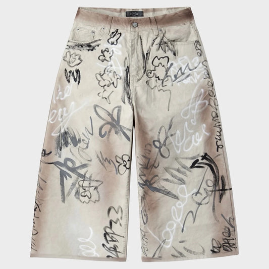 HMDD Banksy Jorts front flat-lay — cream denim jorts covered in hand-drawn graffiti, button fly and front pockets