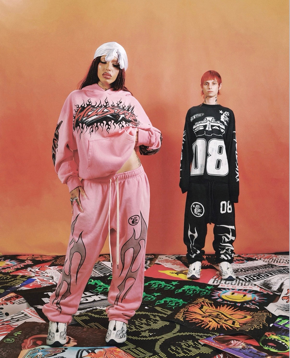 Hellstar Black Racer Sweatpants on a model beside a pink flame hoodie and sweatpants look