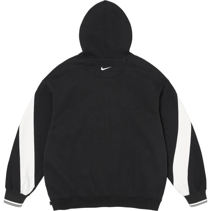 Back of the black Supreme x Nike hoodie with a small Swoosh below the hood and white sleeve panels
