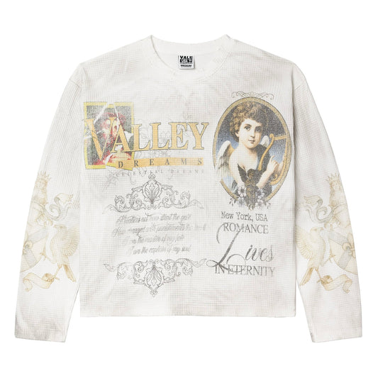 Front of the Vale White Celestial waffle-knit thermal, printed with a gold Valley Dreams box logo, an oval cameo of a winged cherub playing a lyre, Romance Lives Eternity script and gold heraldic griffins down the sleeves