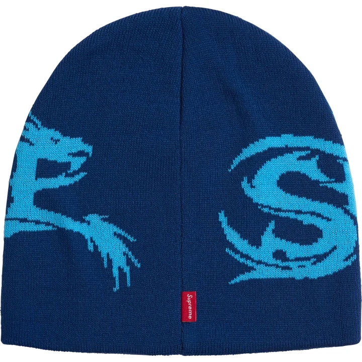 Back of the blue Supreme Dragon beanie showing the cyan dragon tail, a large S and a red woven tab