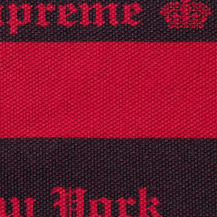 Close-up of the red and navy jacquard knit with red Supreme and New York lettering