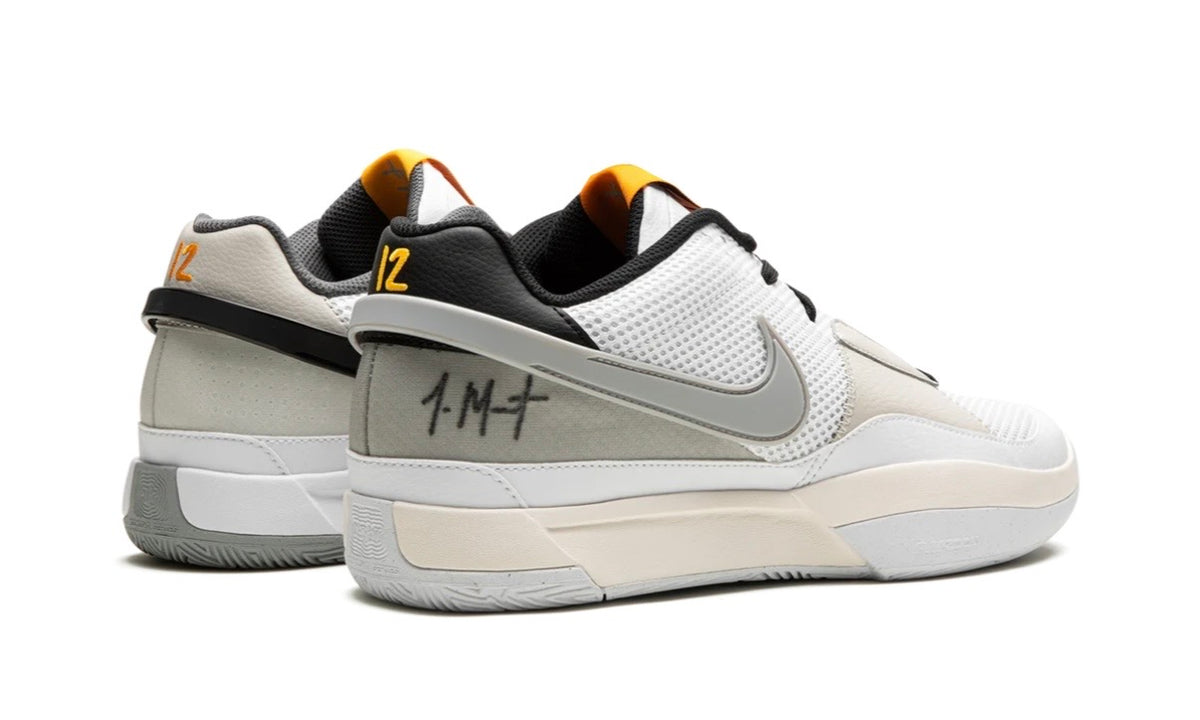 Nike Ja 1 Light Smoke Grey, rear three-quarter view of the pair with Ja's signature on the grey heel and orange tongue logos