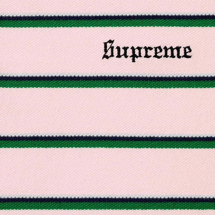 Close-up of the black Supreme script embroidery on the pink striped polo knit