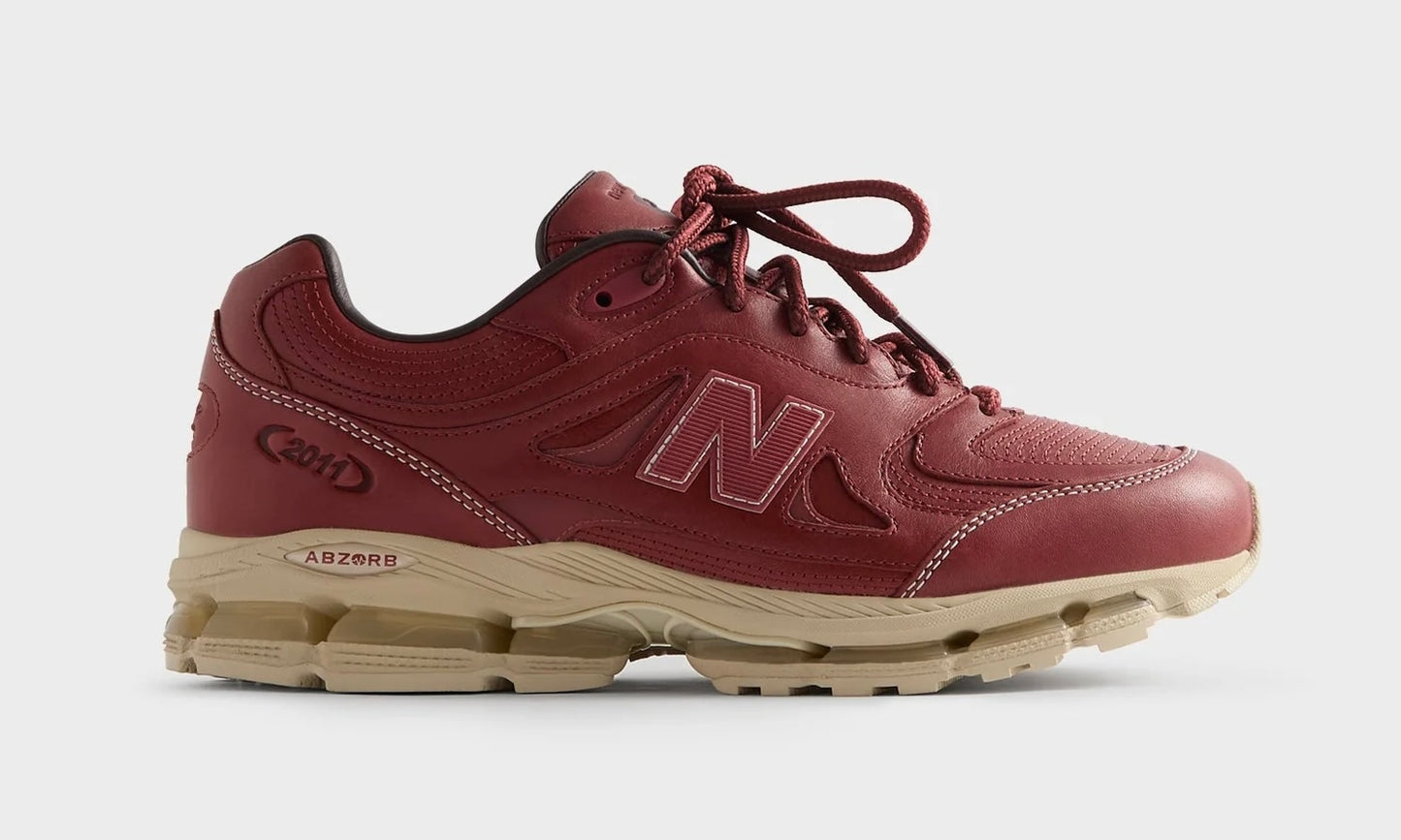 Kith New Balance 2011 Redwood, angled side view of the burgundy leather shoe with matching laces