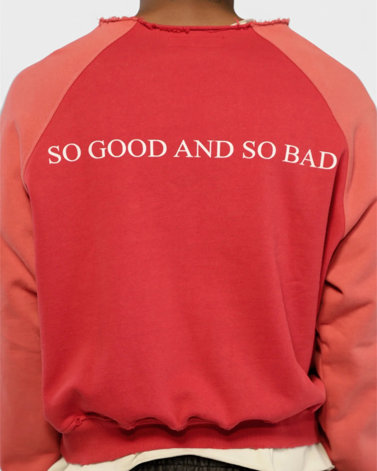 Close-up of the SO GOOD AND SO BAD back print on the red crewneck