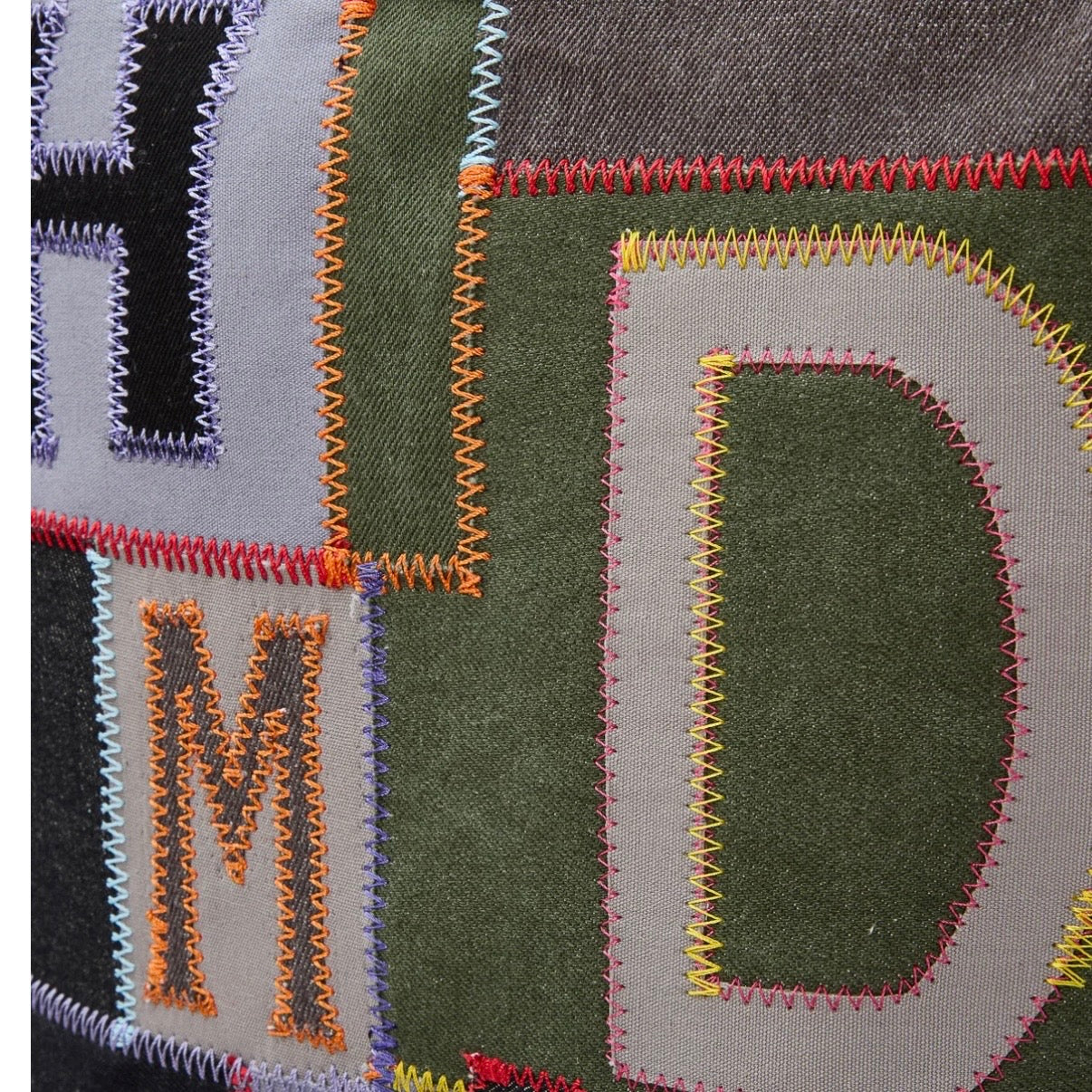 HMDD Hopscotch Box Bag, close-up of the appliqued H, M and D letters blanket-stitched onto green and grey patches