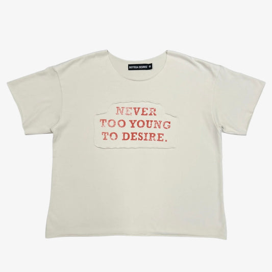 Cream boxy tee with rust-red NEVER TOO YOUNG TO DESIRE applique chest print