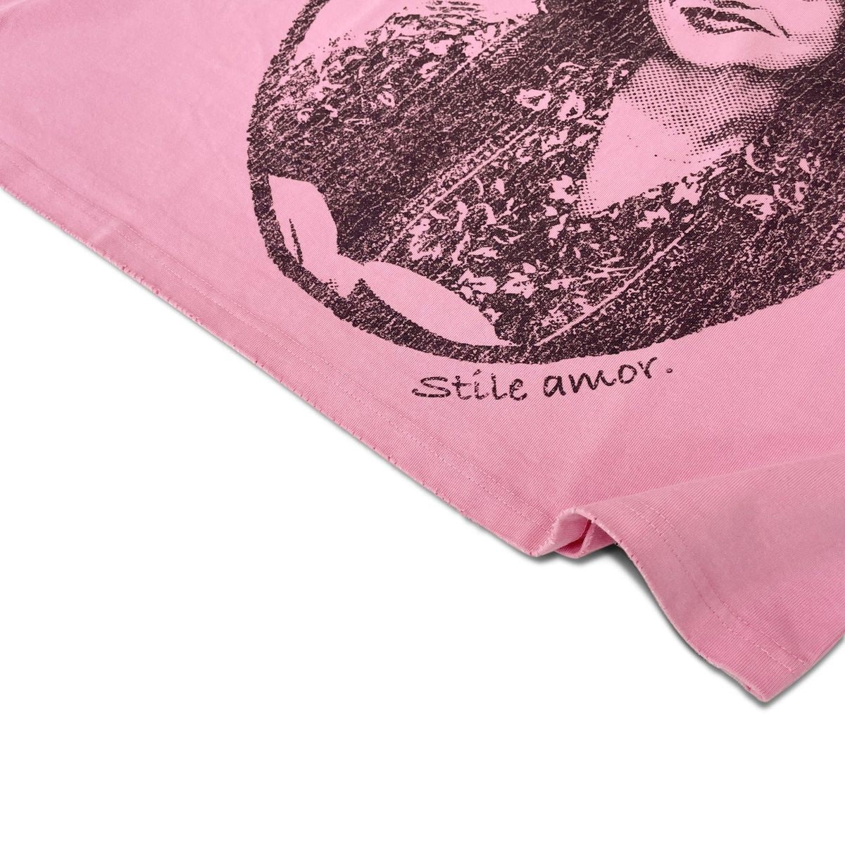 Stile De Amor Pink Cosa Sola T-Shirt, angled close-up of the hem with stile amor script below the portrait print