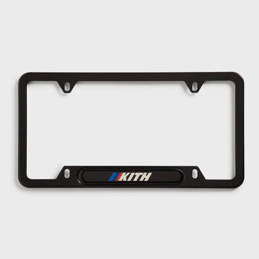 Kith BMW Black License Plate Holder, front view of the black frame with a Kith logo and BMW M stripes on the lower bar