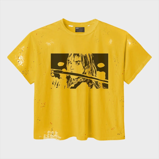 HMDD KB Vintage Tee front — yellow paint-flecked tee with a black-and-white halftone print of a woman holding a katana