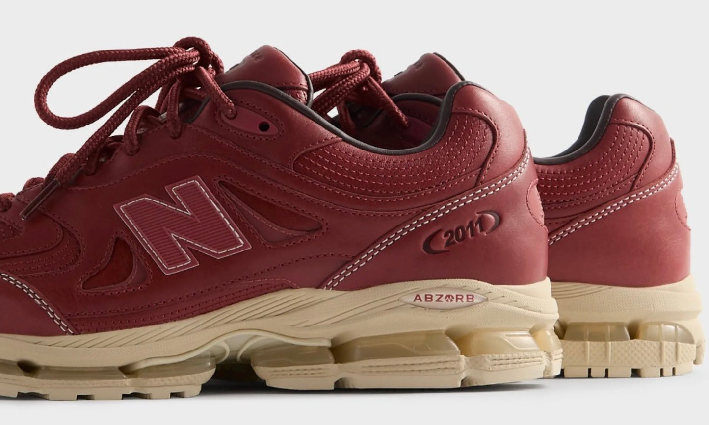 Kith New Balance 2011 Redwood, angled front view of the pair, burgundy leather uppers on tan midsoles